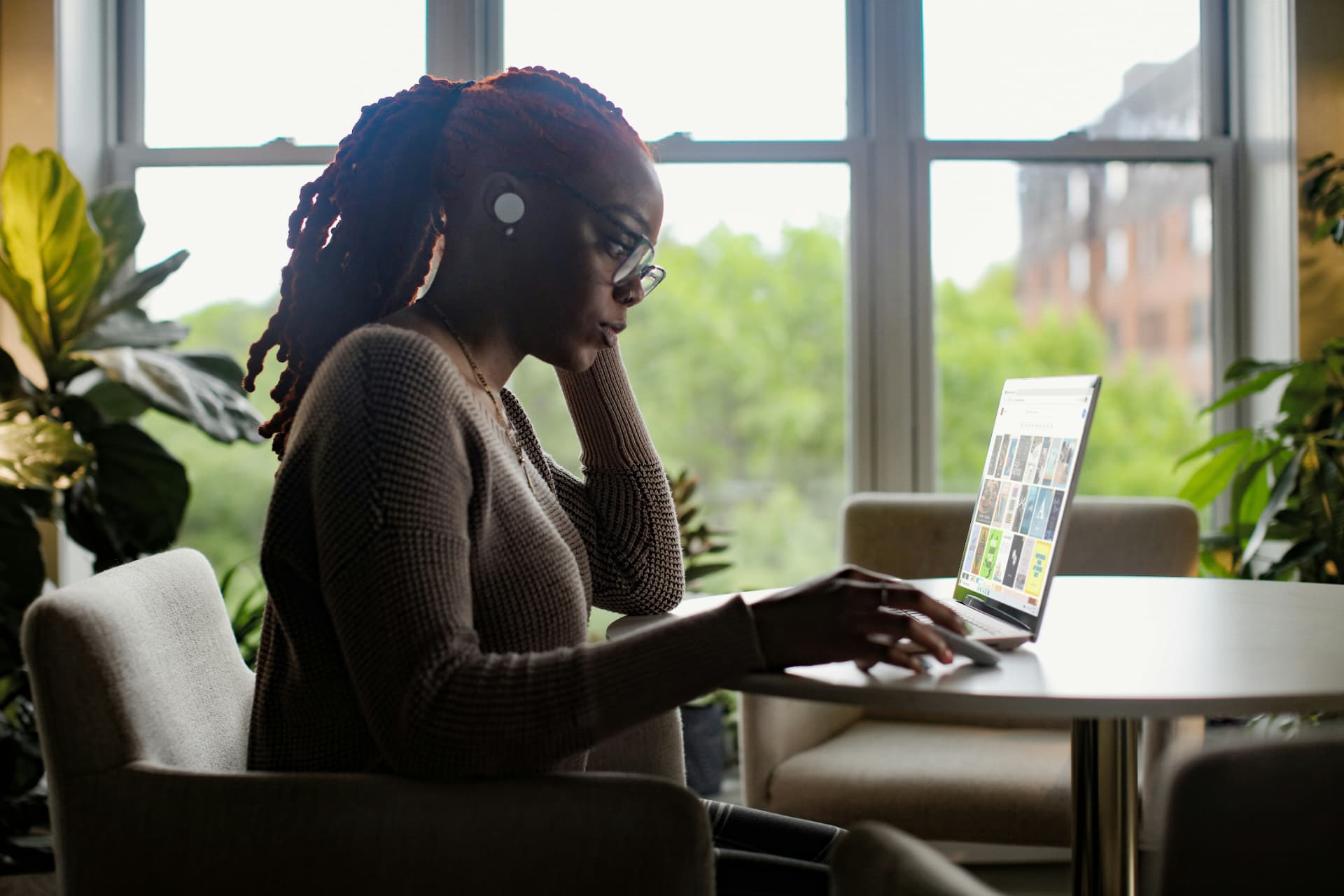 Professional working on a laptop in front of a backlit window